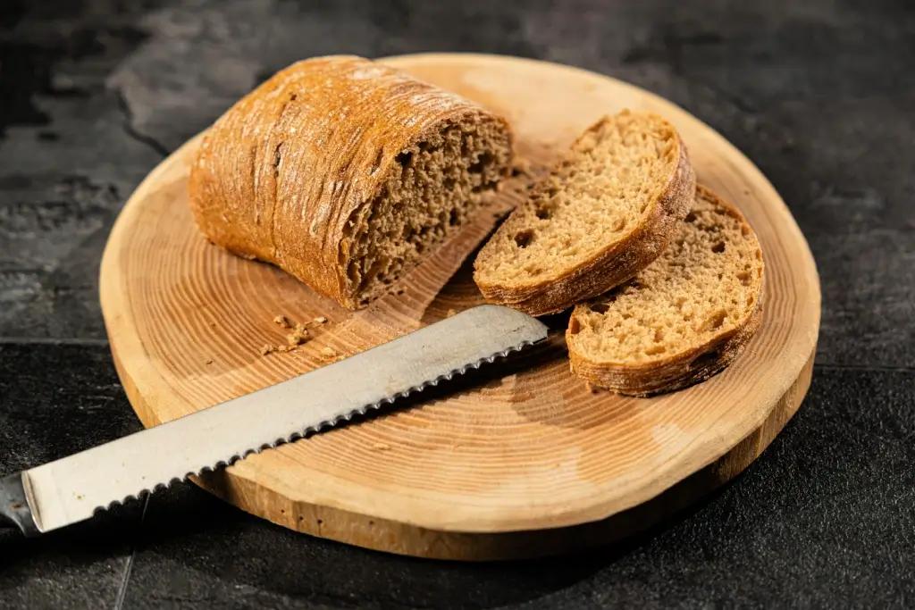 A pankiri (serrated knife) on a plate next to a loaf of brown bread.